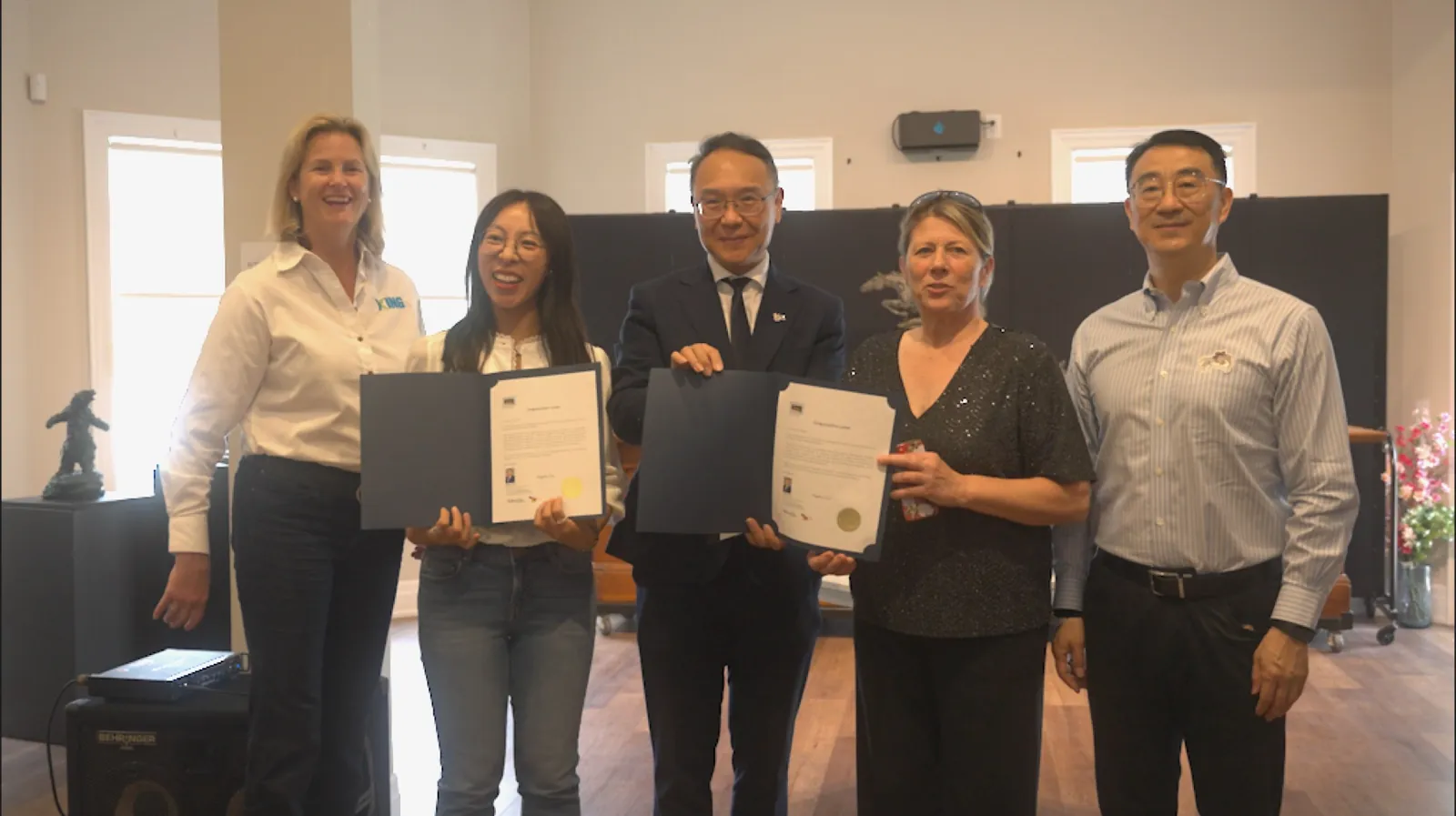 Presenters holding congratulatory letters during the opening