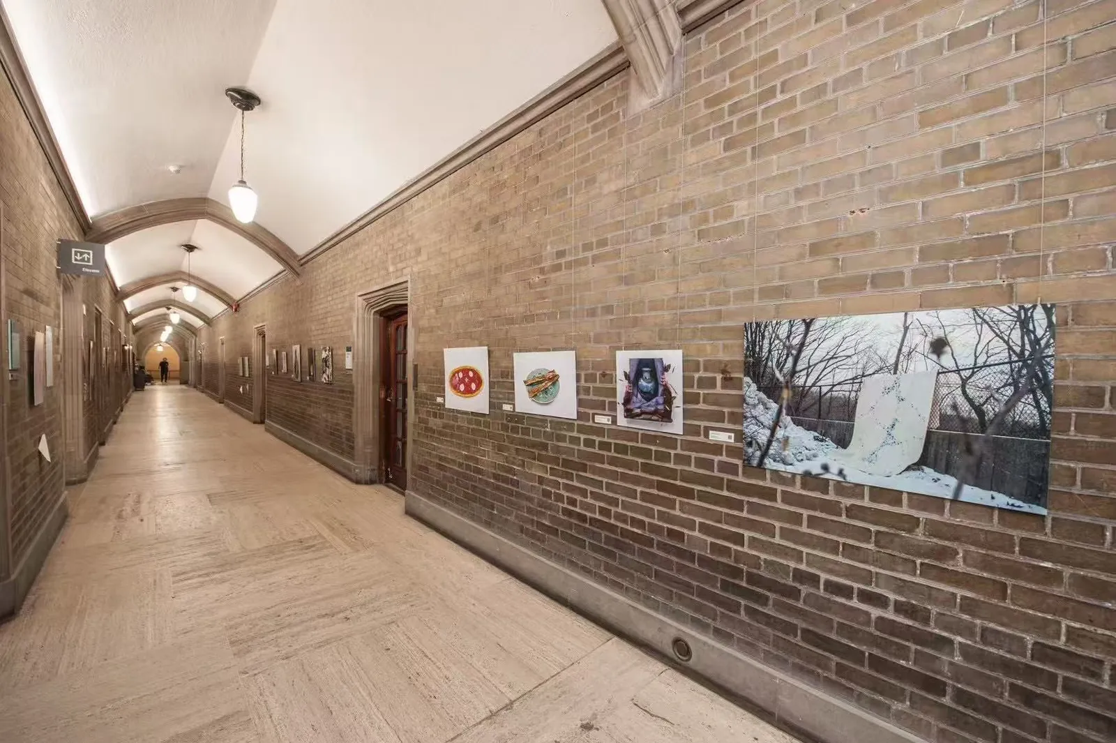 Interwoven Identities artworks installed along a brick corridor at Hart House