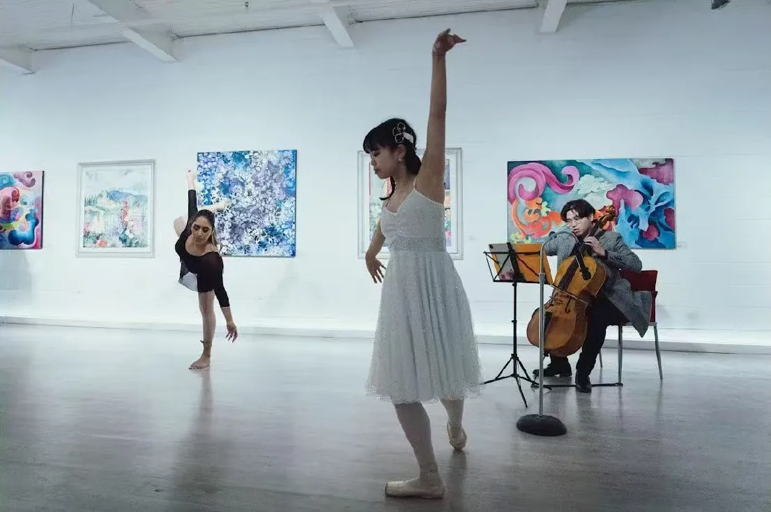 Two dancers performing with a cellist in the gallery