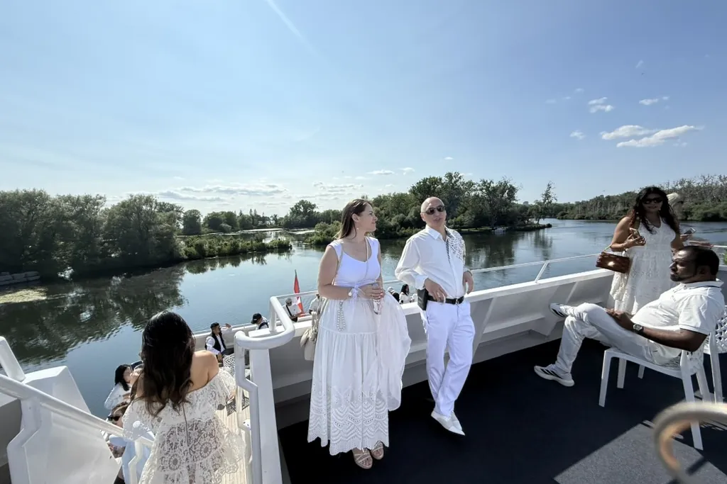 Guests dressed in white on the boat's upper deck